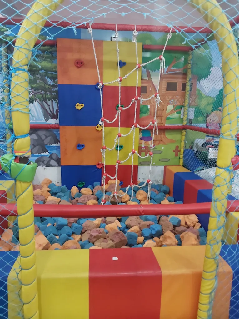 Soft play climbing wall with safety rope net and foam pit